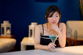 A picture of a pretty young asian woman sitting alone at a table